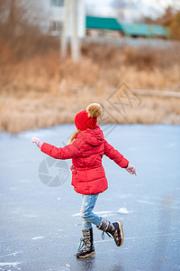滑冰的小女孩可爱的小女孩在冰场滑冰滑冰场速度教学手套帮助孩子溜冰场女孩爱好喜悦背景