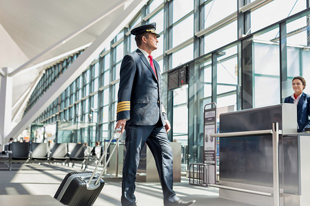 驾驶员在机场登机门上步行进入飞机的成熟飞行员航班护照男人旅行飞机场手提箱国际航空公司工人黄色背景