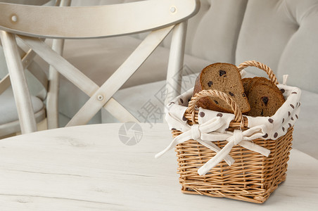 面包中有一个圆篮子椅子饮食粮食糖类烘烤白色葡萄干桌子产品硬皮背景图片