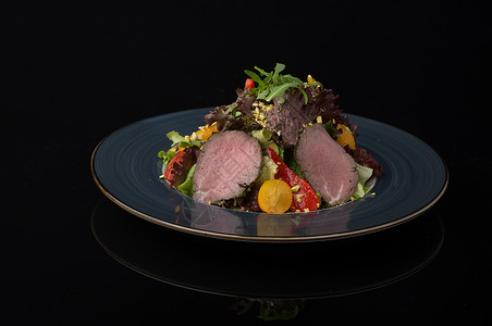 黑背景的盘子圆形反射叶子黑色蔬菜午餐油炸餐厅牛肉美食背景图片