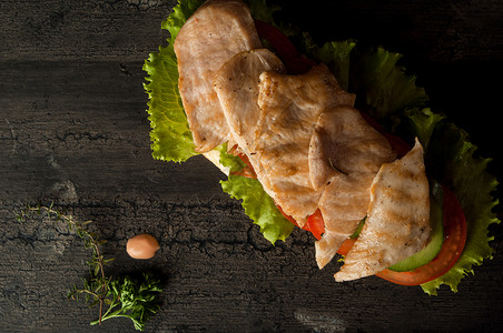 木质表面的芝士汉堡沙拉芝麻午餐牛肉叶子黑色木板木头包子酒吧背景图片