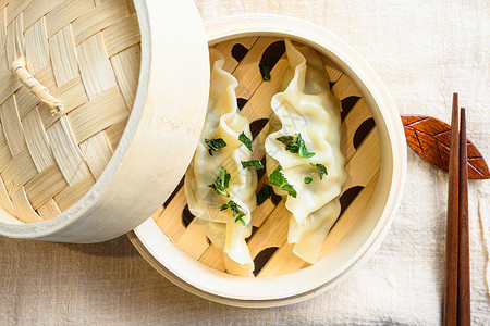 中国小吃 中国蒸饺 木蒸锅 饺子小吃 亚麻布上的中国传统美食 在白色质感的石桌上供应 特写背景图片