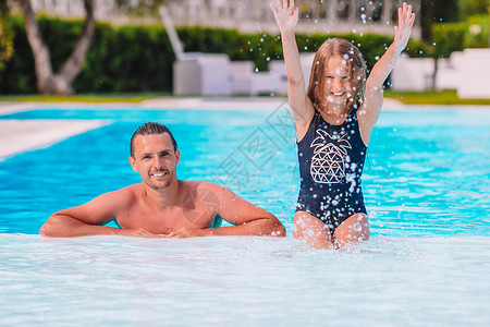 母亲和小女儿的家庭在豪华游泳池中享受暑期假期奢华成人日光浴乐趣幸福游泳酒店女孩黑发蓝色背景图片
