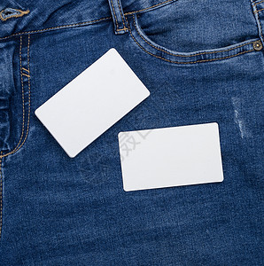 蓝色牛仔裤背景上的空白白皮书名片背景图片