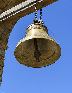 一个大铜铃 挂在木形十字横梁上背景图片