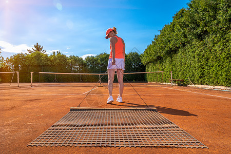 在一个户外网球场上的柳橙粘土天空游戏打扫场地扫帚玩家运动活动闲暇地面背景图片
