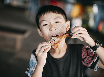 以吃鸡腿为食的亚裔男孩背景图片