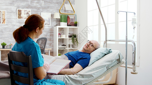 躺在疗养院医院床上的老年退休病老人诊所女性男人养老院女士说谎护理男性成人病人背景图片