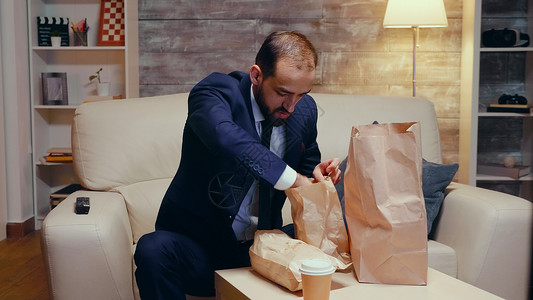 跟踪饥饿商务人士回家的一拍照片商务食品正装公寓男人长椅遥控程序薯条人士背景图片