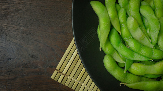 Edamame在黑色板块上显示食物含量的最高视图图像营养豆类蔬菜大豆饮食美食绿色小吃桌子毛豆背景