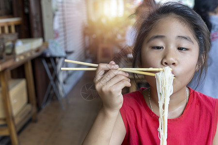 穿红裙子的亚洲女孩吃小面条汤C面条幸福筷子桌子午餐乐趣食物男人餐厅成人美食高清图片素材