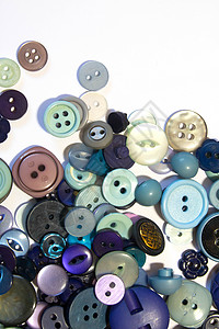 多色不同尺寸按钮的集合缝纫圆圈绿色黄色工艺纽扣圆形塑料白色纺织品背景图片