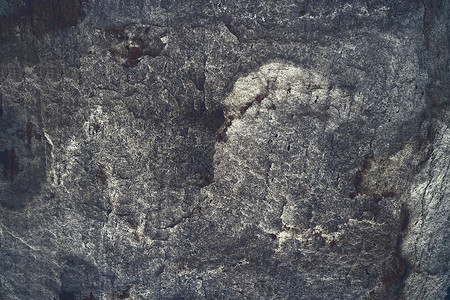 古代灰色灰烬花岗岩石表面的洞穴内部背景图片