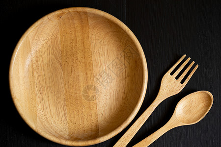 用叉子刺一下黑木木柱上用木制成的勺子 叉子和迪什乡村营养餐厅食物用具飞碟厨房烹饪桌子盘子背景