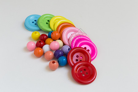 五颜六色的按钮和珠子工艺团体玩具手工孩子们孩子黄色艺术纽扣红色背景图片