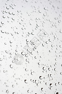 倾斜窗口的雨滴灰色液体反射天气玻璃水滴窗户气泡团体背景图片