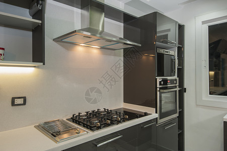 在豪华公寓的现代厨房风格烤箱炉灶家具排气扇架子器具电烤箱柜台装饰背景图片