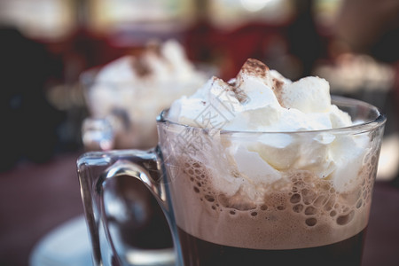 葡萄牙一家小咖啡厅露台旁的维安朱古力巧克力泡沫甜点沙漠拿铁早餐鞭子肉桂咖啡奶油咖啡店背景图片