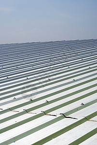 仓库金属板屋顶建筑床单天空灰色材料工业涂层商业瓦楞栅栏背景图片