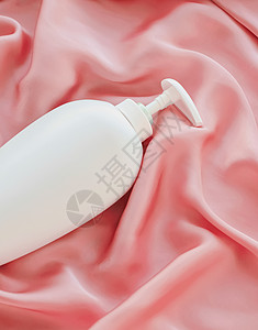 白标签化妆品容器瓶 作为粉色丝丝底的模拟产品卫生液体洗发水塑料浴室肥皂包装奶油品牌凝胶背景图片