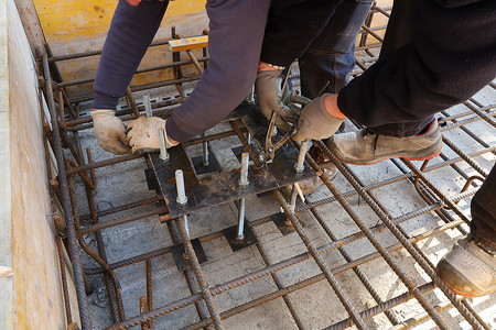 工人在钢板上架起铁板 并用锚螺栓固定柱子背景图片