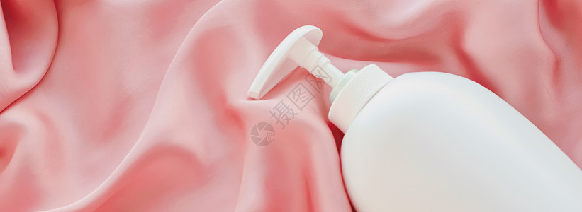 白标签化妆品容器瓶 作为粉色丝丝底的模拟产品塑料奶油液体消毒剂润肤奢华浴室保健淋浴凝胶背景图片