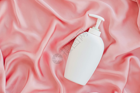白标签化妆品容器瓶 作为粉色丝丝底的模拟产品瓶子凝胶肥皂小样洗发水皮肤保湿身体卫生液体背景图片