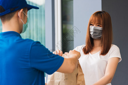 青年男子提供快餐纸袋的快餐 t疾病运输面具男人导游工作船运送货女士邮递员脸高清图片素材