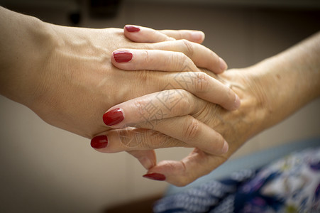患有老年痴呆症的老年人的手老化成人帮助女士家庭医院老年护理病人女性背景图片