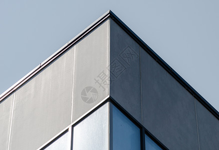 有窗户的灰色混凝土大楼拐角办公室石头墙壁房子面板积木建筑城市蓝色背景背景图片