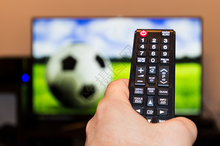 在现代电视电视上观看足球足球比赛 并剪辑房间技术电视快乐按钮电影乐趣手表拇指控制居住高清图片素材