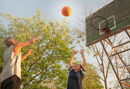 亚裔年长男子在夏日运动场打篮球活动高清图片素材