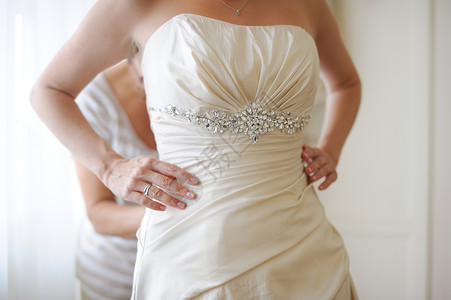 穿上婚纱裙子婚礼新娘庆典帮助衣服女士白色奢华背景图片