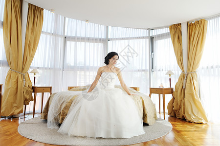 在豪华酒店房间的美丽新娘奢华工作室裙子公主座位婚姻沙发福利古董婚纱背景图片