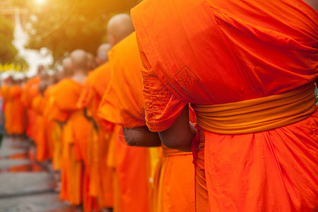 泰国僧侣佛教慈善事业的概念 清晨 僧侣们排成一排等待佛教徒在泰国寺庙施舍 在前面和尚的选择性焦点 具有镜头光晕效果的灯背景
