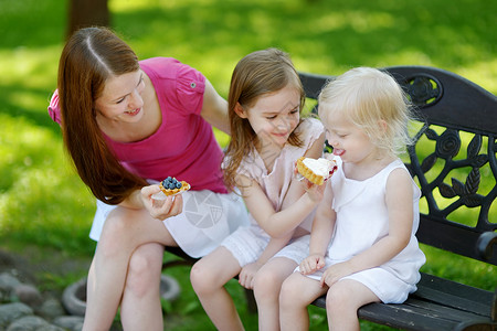 两个小姐妹 分享美味的奶油甜点女性母亲兄弟成人享受女孩姐姐朋友女士舌头童年高清图片素材