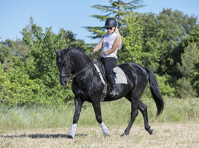 骑马的女童和女童动物骑士运动骑术黑色头盔训练活动女孩闲暇背景图片