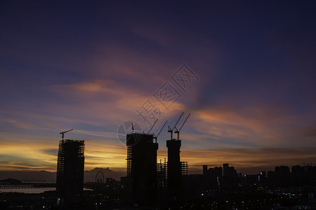 日落时建筑工地天空工程建筑学工业起重机太阳工作城市橙子商业背景图片