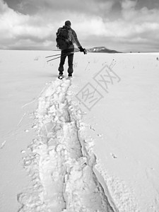 背负着雪鞋的爬山者 在山上行走的人雪裤男士阴影鞋套曲目爬坡单身运动成年人休息登山杖高清图片素材