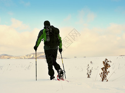 旅行者检查雪鞋 穿冬夹克和大背包的山顶雪中漫步场地男士爬坡粉雪手套鞋套漂移单身冒险曲目霜高清图片素材