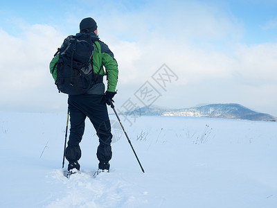 有雪鞋的男人在雪中休息 爬雪鞋手套男士远足鞋套登山杖背包荒野跨步呼吸场景粉雪高清图片素材