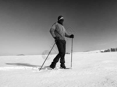 有雪鞋的观光客在雪地漂流中行走 阳光寒冷的天气运动护颈曲目远足晴天跨步手套冒险运动员荒野冬季高清图片素材