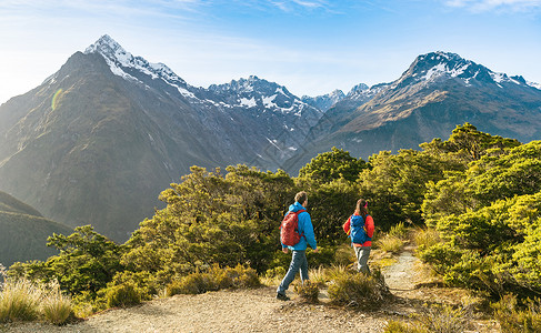 在新西兰Fiordland国家公园度假时 Hikers穿着背包在关键高峰会轨道上踩脚踏步而行的希克尔斯人骑着背背包旅行背景图片