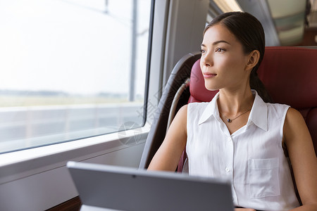 火的使用素材在火车上使用笔记本电脑旅行的亚洲妇女 商业妇女通过计算机工作 在往返上班时向窗外看望着窗口背景
