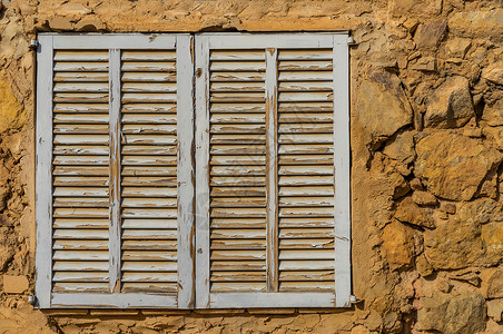 旧的窗口百叶窗特征木质外观房子石材风化乡村建筑灰色文化背景图片