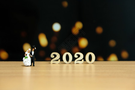具有2020年木制号码的微型人物 新娘和新郎季节男人邀请函礼物男生卡片女士烟花蜡烛庆典背景图片