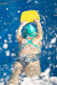 在游泳池训练可爱的小女孩 在一个游泳池里游泳衣闲暇女性蓝色泳装水池眼镜运动女孩游泳蓝色的高清图片素材