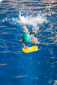 在一个游泳池中训练可爱的小女孩游泳训练蓝色游泳者幸福泳装游泳衣喜悦眼镜女孩女性孩子运动高清图片素材
