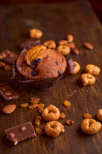 在一张木桌上的巧克力玛芬用巧克力和塔塔里尼宏观产品坚果作品木板清洁可可蛋糕奶制品葡萄干背景图片