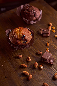 在一张木桌上的巧克力玛芬用巧克力和塔塔里尼宏观产品盘子奶制品可可杏仁作品清洁木板坚果背景图片